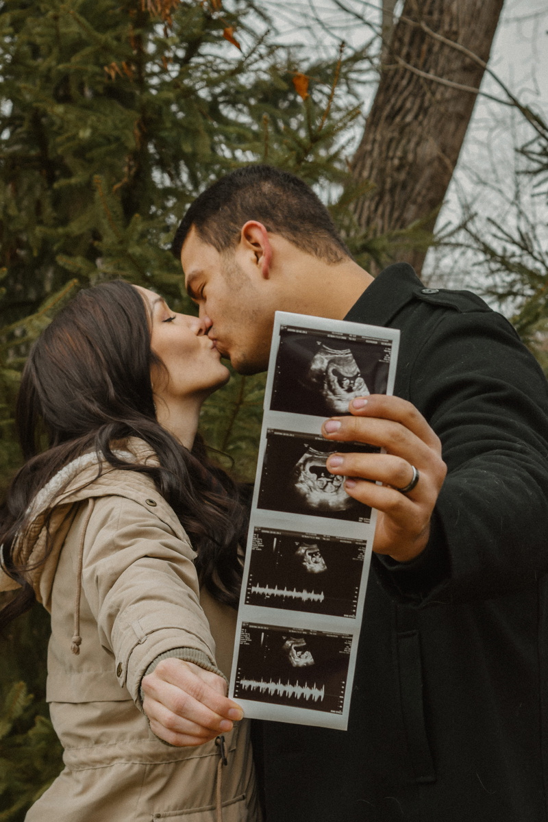 communication, standing, baby, woman, plant, coats, men, wearing, beside, couple - relationship, black, adult, real people, two people, tree, lifestyles
