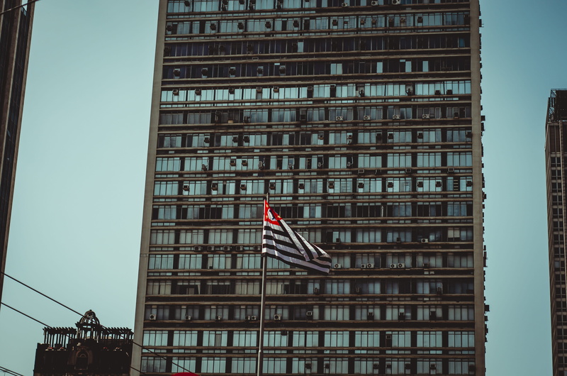architectural design, flag, striped, patriotism, low angle shot, downtown, window, construction, outdoors, office, exterior, skyscraper, perspective, no people