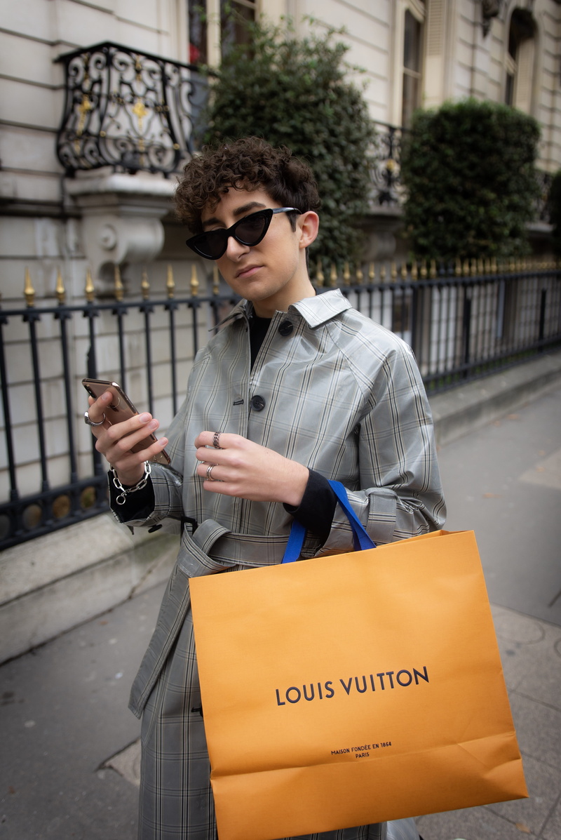 sleeve, glasses, person, handbag, wireless technology, leisure activity, one person, text, phone, lifestyles, screen, young men, carrying, clothing, shopping