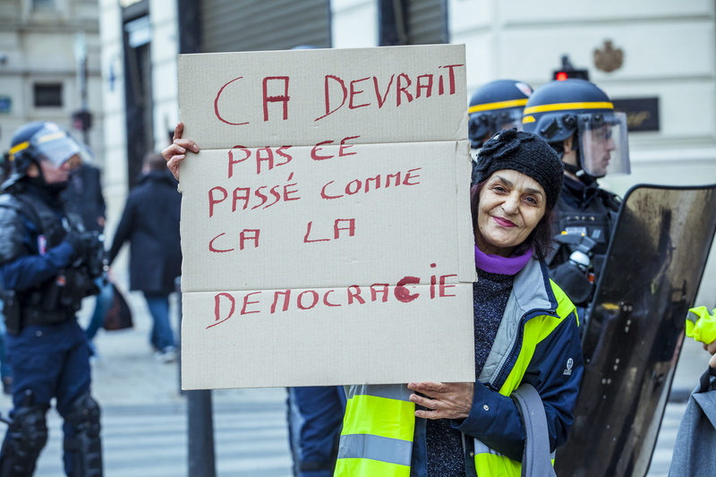 clothing, focus on foreground, placard, officer, transportation, message, men, city, holding, standing, crowd, pedestrian, group of people, protestor, helmet