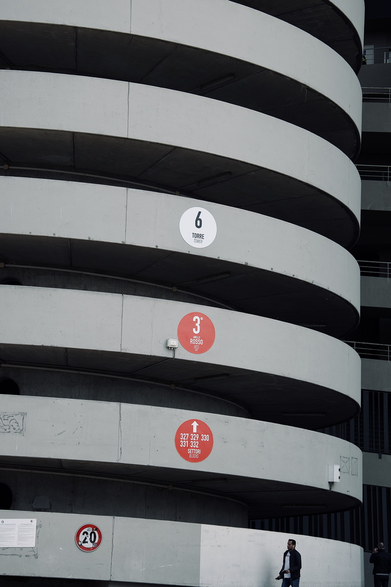 human, building, symbol, road sign, handrail, building exterior, banister, alphabet, pedestrian, word, wall - building feature, vehicle, transportation