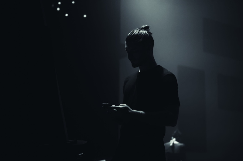 black, stage, lifestyles, dark, 1080P, domestic room, indoors, phone, emotion, adult, sadness, wearing, silhouette, waist up, shirt, mobile phone, man bun
