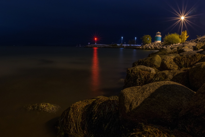 dark, shore, tree, white, building exterior, bridge - man made structure, lighthouse, water, rocks, trees, beside, rock, illuminated, outdoors, rock - object