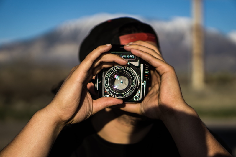 camera - photographic equipment, women, sun, black, cap, adult, focus on foreground, holding, hat, photographing, technology, photography, photographic equipment