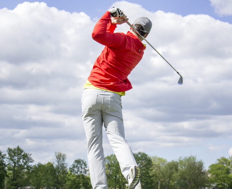 low angle view, leisure activity, one person, sky, playing, holding, casual clothing, tree, plant, shirt, golf, long, sports backgrounds, taking a shot - sport