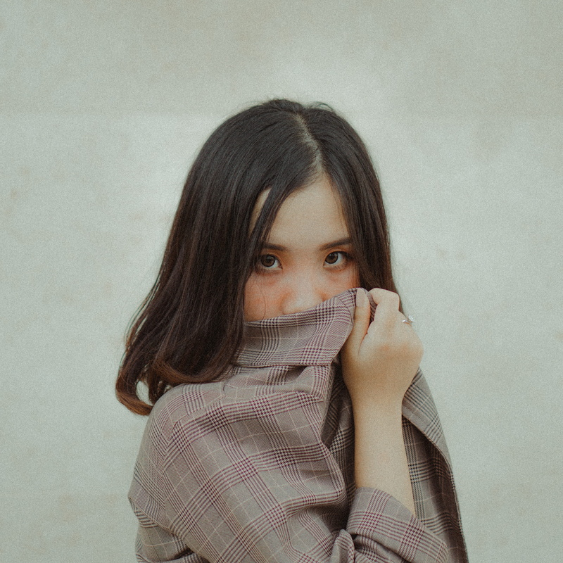 wall - building feature, gown, one person, face, long sleeve, young adult, obscured face, long hair, using, suit, sleeve, scarf, sweater, front view, lifestyles