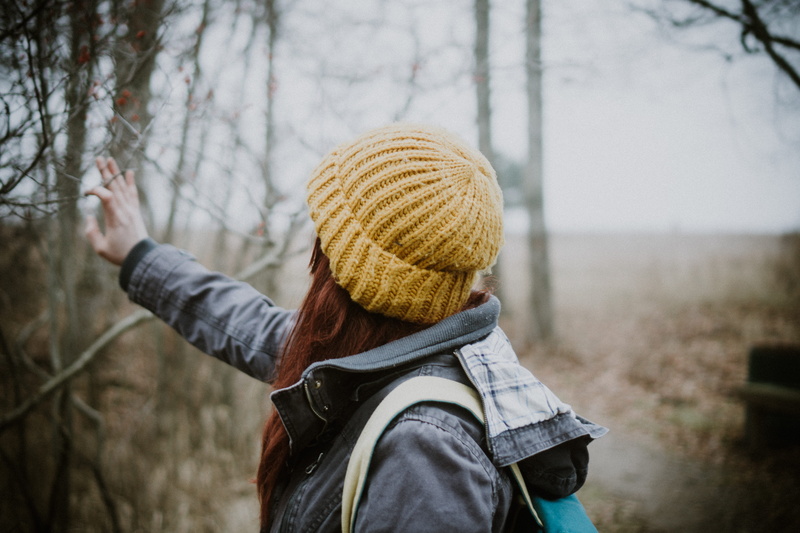 woman, arms raised, winter, yellow, hood, person, text, wearing, leisure activity, tree, apparel, rear view, human limb, headshot, photo, portrait, day
