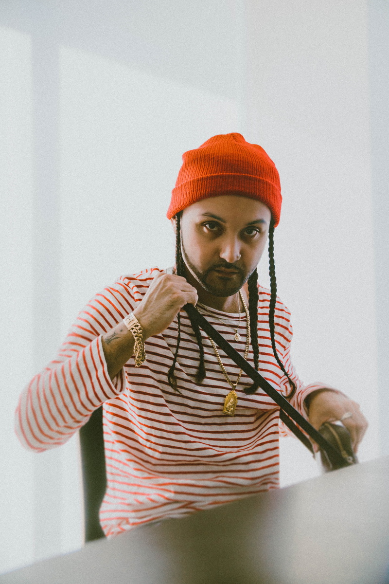 man, indoors, red, person, young adult, bed, apparel, bathing cap, wearing, one person, bonnet, warm clothing, real people, waist up, clothing, hat, striped