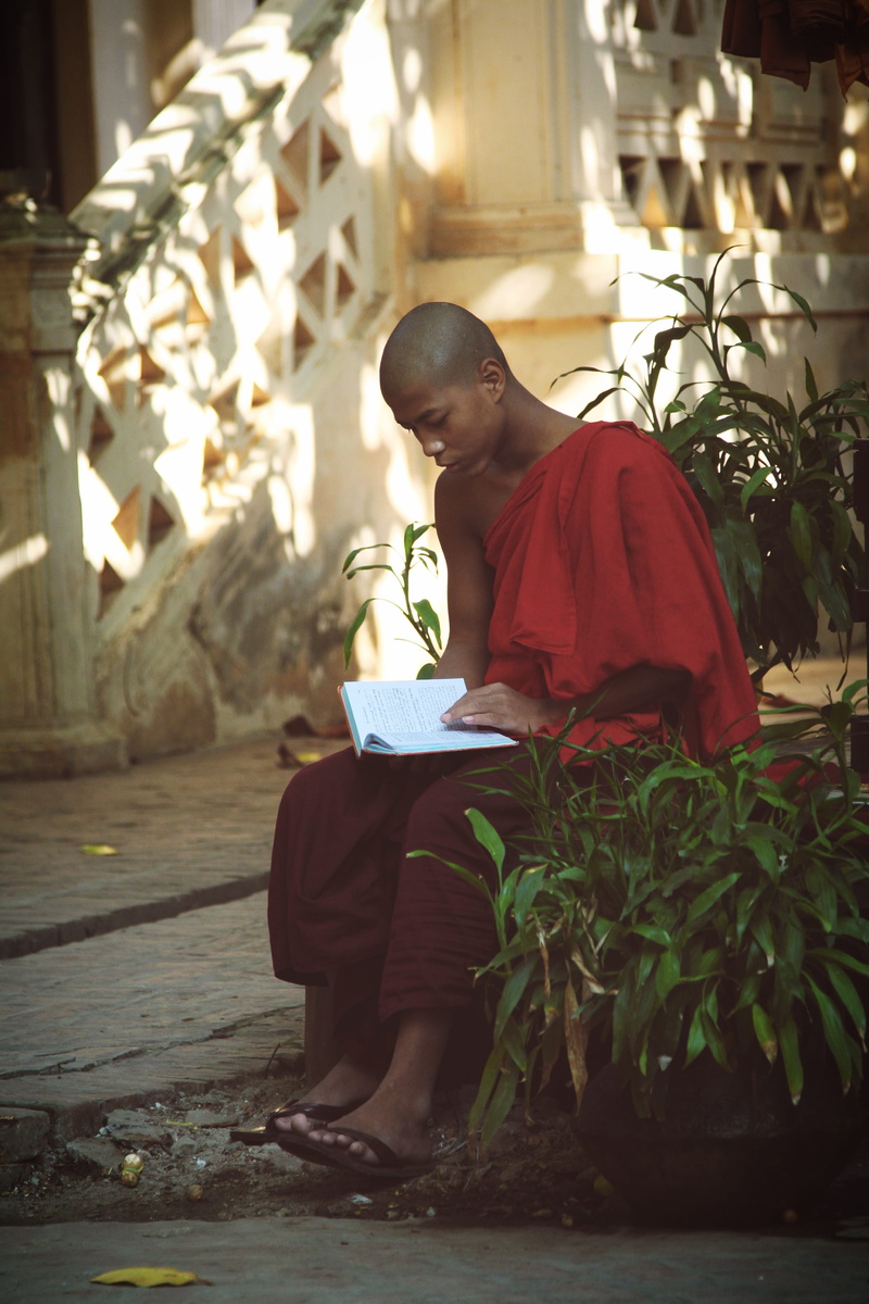 education, real people, built structure, spiritual, looking, lifestyles, activity, front view, architecture, young men, sitting, pray, young adult, men