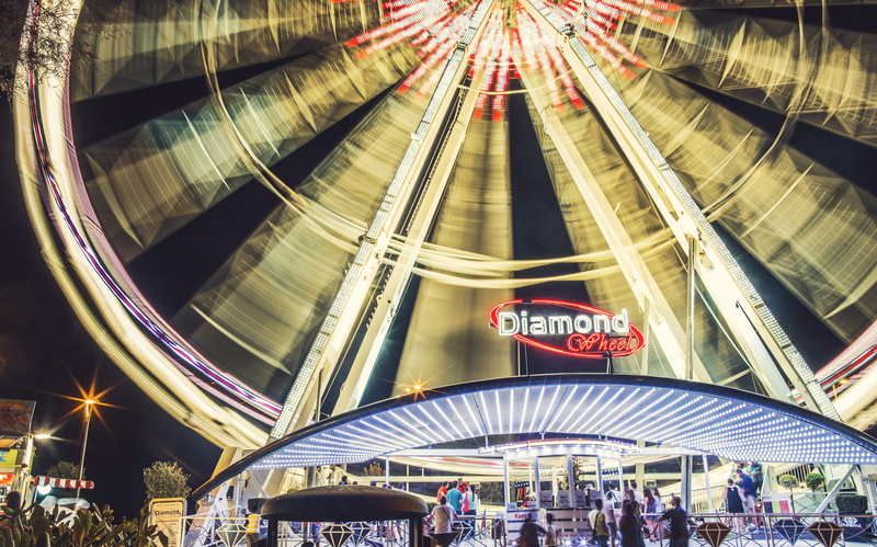 built structure, fun, outdoors, city, ride, text, real people, attraction, lifestyles, large group of people, hustle and bustle, travel destinations, illuminated