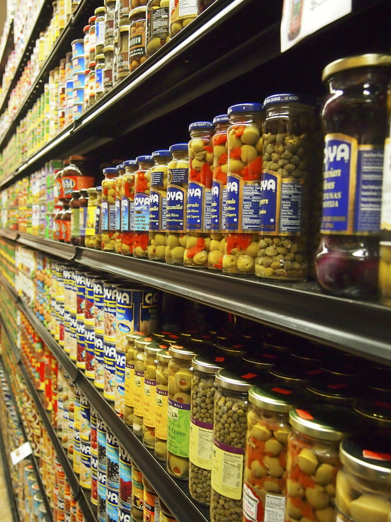 jar, retail display, indoors, jars, in a row, shop, glasses, abundance, for sale, person, groceries, shelf, food, supermarket, food and drink, arrangement