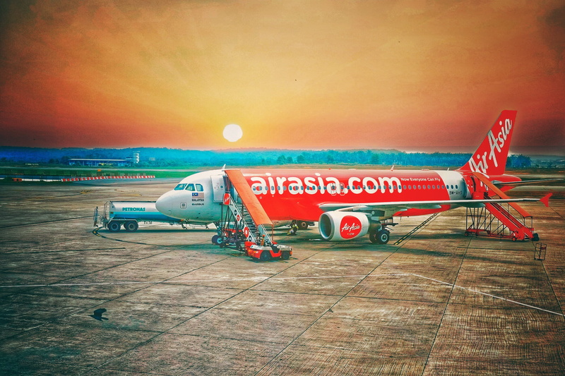 text, air vehicle, airport runway, airasia, sunset, no people, mode of transportation, land vehicle, safety, western script, red, sign, nature, airline