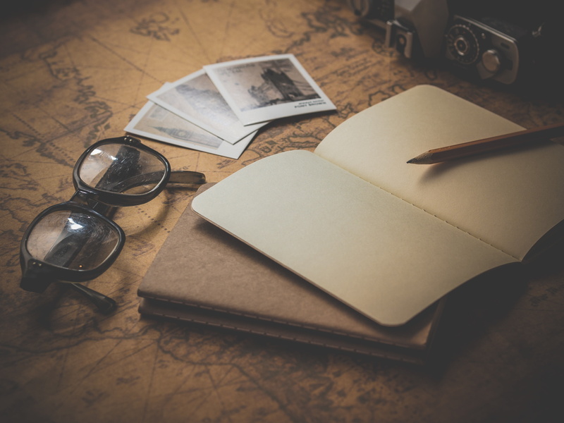 note pad, table, book, publication, document, pen, map, indoors, books, glasses, small group of objects, paper, fountain pen, group of objects, eyeglasses