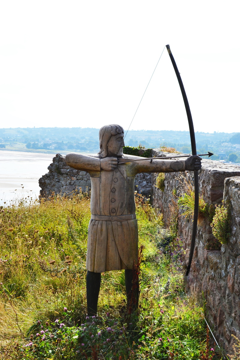 full length, outdoors, warm clothing, leisure activity, one person, mont orgueil castle, figure, sea, nature, non-urban scene, real people, english longbow