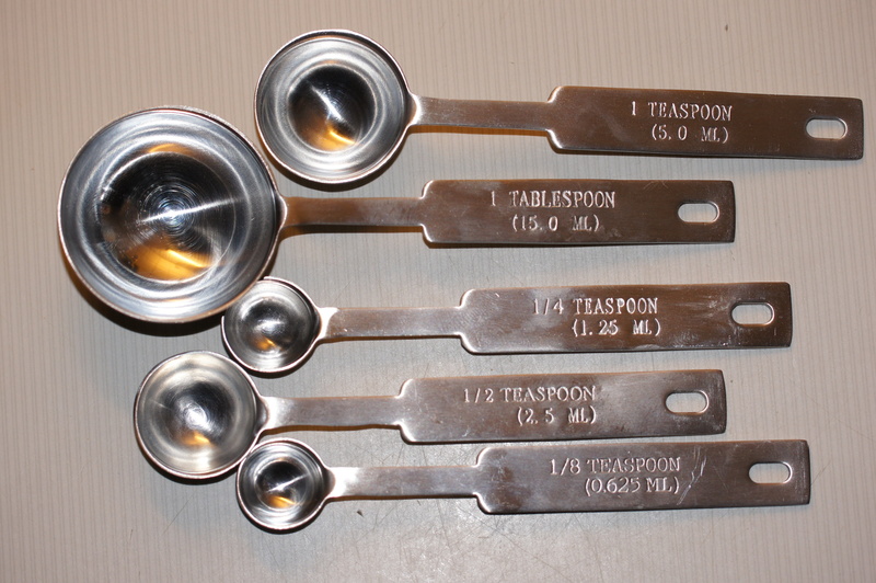 measuring spoons, silver colored, no people, baking, large group of objects, orthographic symbol, indoors, sign, table, wood - material, cooking, directly above