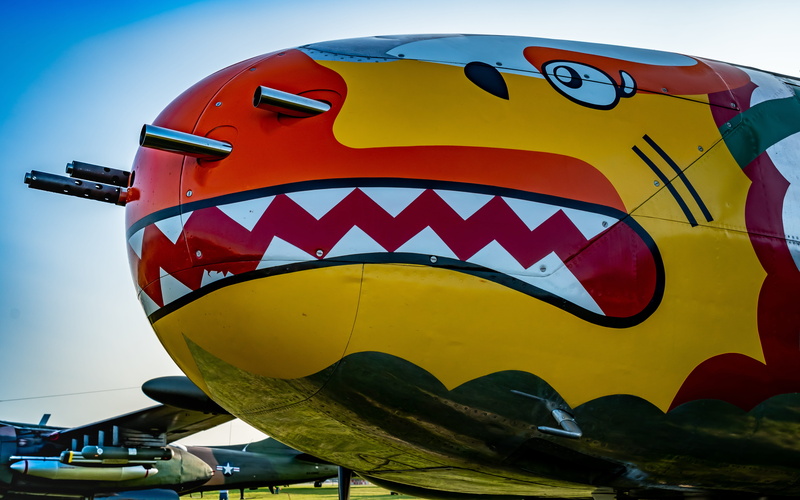 no people, ww2, aircraft, plane, built structure, outdoors, sky, vintage, multi colored, text, propeller, red, old, amusement park ride, military, low angle view