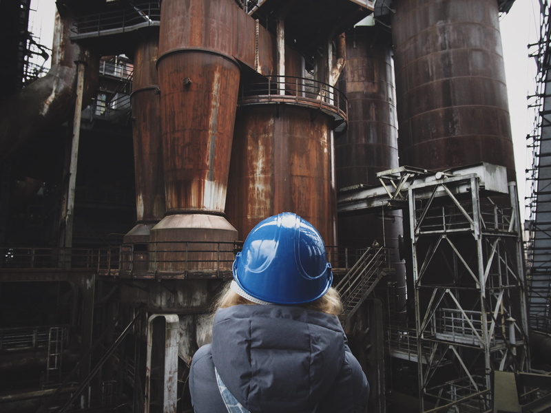 factory, outdoors, hardhat, building exterior, helmet, girl, refinery, construction, apparel, hard, waist up, old, day, built structure, industry, hat