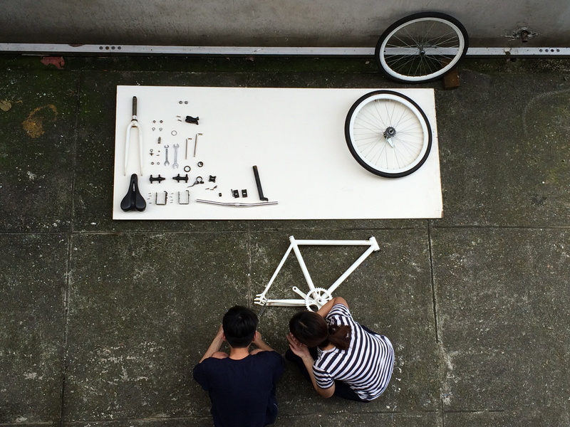 component, bicycle, details, males, man, constructor, woman, casual clothing, clock, time, rear view, architecture, wheel, communication, crouching, striped