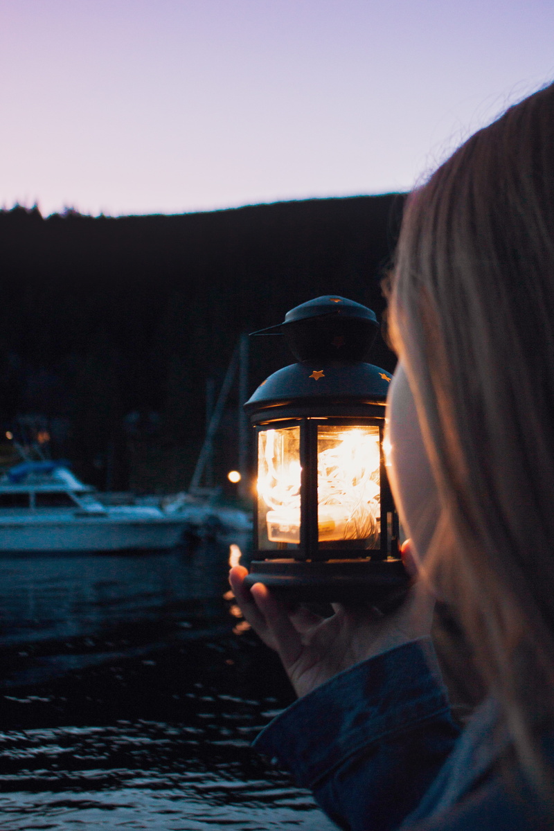 person, holding, nature, spoke, ocean, rear view, lampshade, dock, strap, women, lifestyles, lantern, boat, sky, girl, human, adult, light fixture, fire