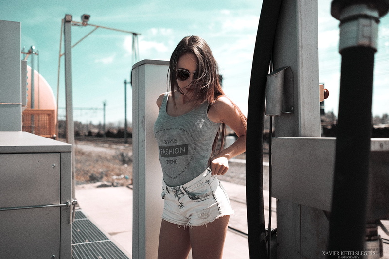 watermarked, shorts, three quarter length, one person, T-shirt, real people, brunette, built structure, young women, young adult, standing, hairstyle, sunglasses