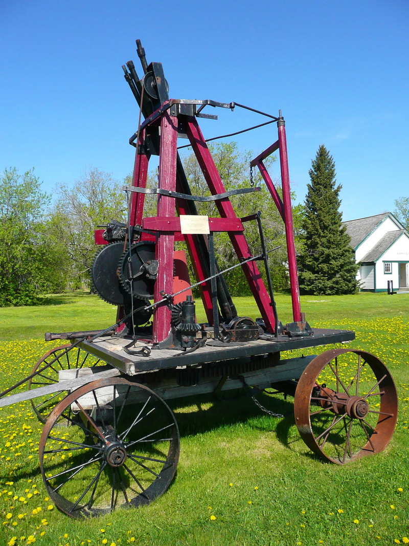field, land vehicle, 2K, sunlight, grass, steinbach, architecture, tree, old pump, outdoors, manitoba, antique, land, sky, mennonite heritage village