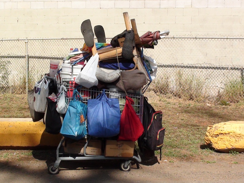 bags, homeless, fence, scooter, unemployed, wall, casual clothing, sunlight, nature, poor, belongings, mode of transportation, one person, transportation