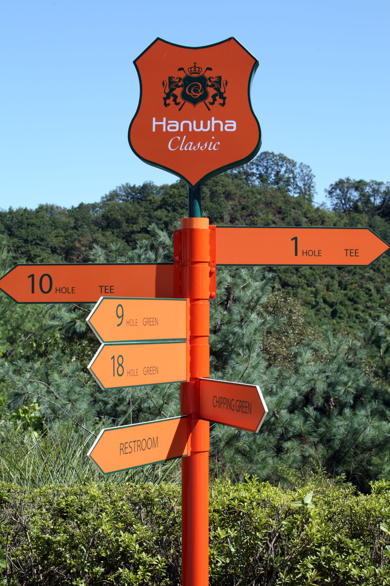 tree, text, symbol, no people, arrow symbol, golf players, golf course, non-western script, nature, information, road, western script, road sign, directional sign
