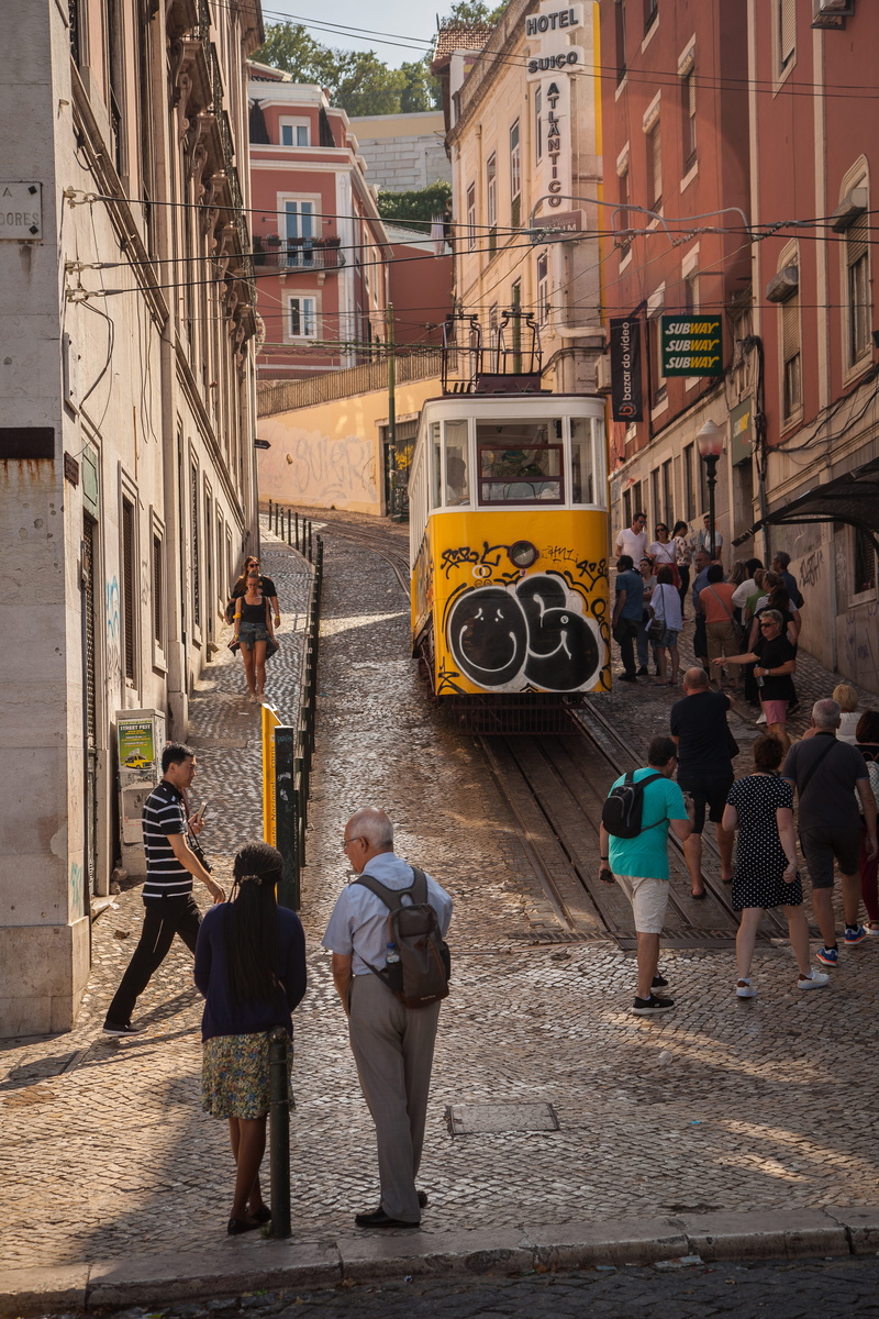 group of people, shoe, pram, rear view, city, person, architecture, land vehicle, rail, clothing, men, city life, day, bus, train track, tram, apparel