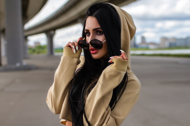long hair, white nails, portrait, lipstick, make-up, clothing, looking away, hoods, bridge, outdoors, 2K, sunglasses, holding, beautiful woman, beauty