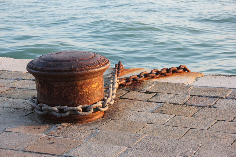 nature, cleat, bollard, sea, rusty, metal, transportation, post, tied down, rope, sunlight, paving stone, outdoors, day, pier, water, high angle view, anchorage