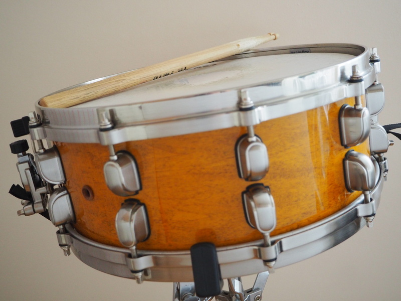 sign, percussion instrument, small drum, indoors, still life, saucepan, sticks, single object, instrument, snare drum, group of objects, no people, golden