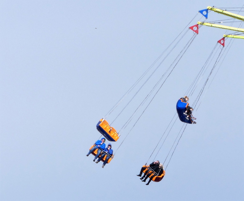 arts culture and entertainment, amusement park ride, outdoors, people, group of people, fun, motion, hanging, real people, chain swing ride, low angle view