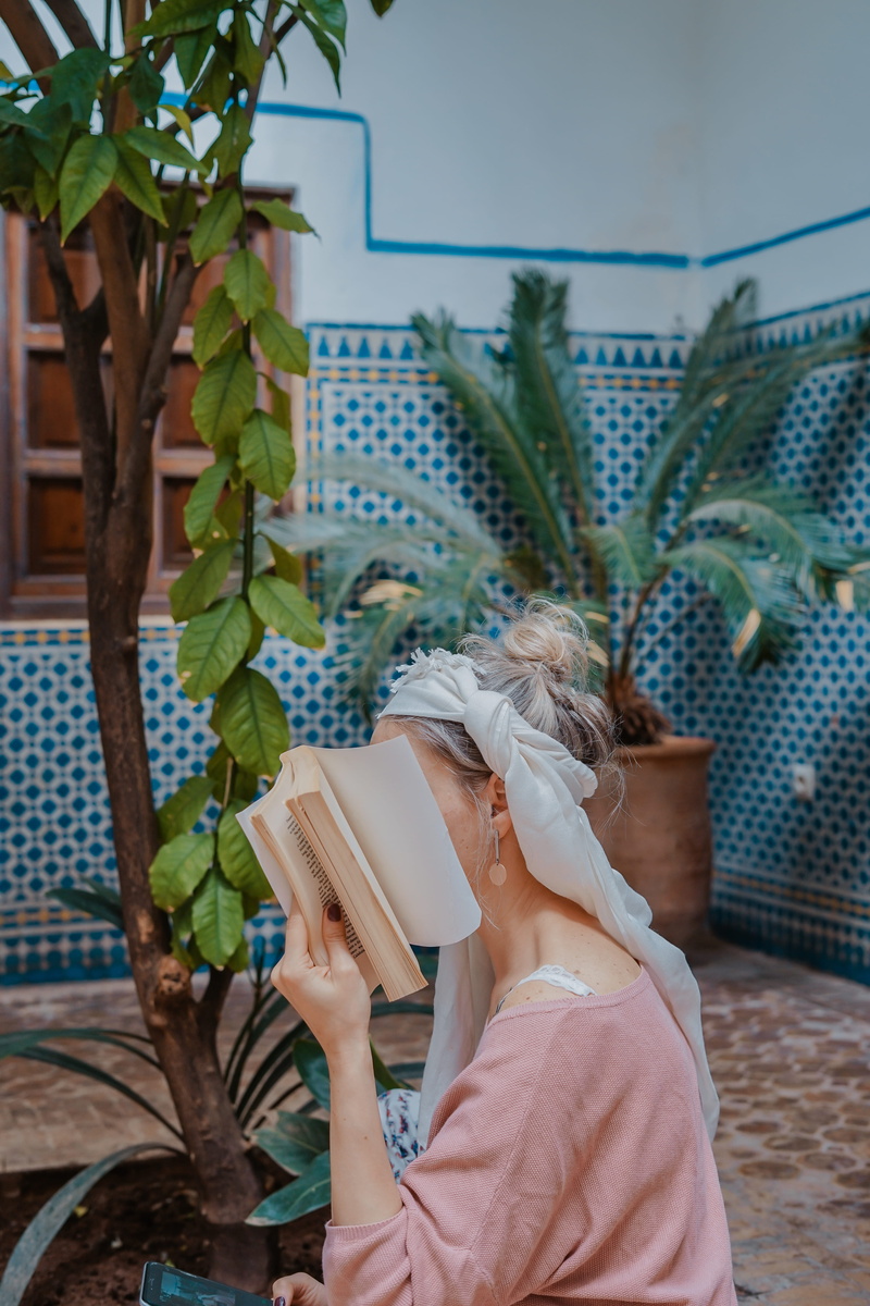 interior design, headshot, outdoors, face, hidden face, holding, reading, activity, palnt, women, hairstyle, hidden, morocco, tree, real people, 5K, person