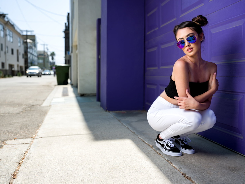 beautiful woman, glasses, depth of field, hairstyle, one person, women outdoors, fashion, squatting, young adult, sunglasses, building exterior, day, lifestyles