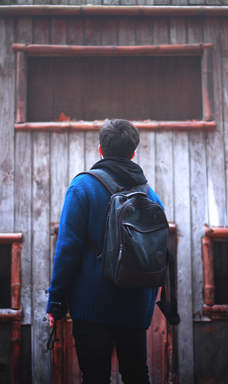 scarf, rear view, built structure, men, one person, warm clothing, day, leisure activity, jacket, building exterior, lifestyles, hood - clothing, walking