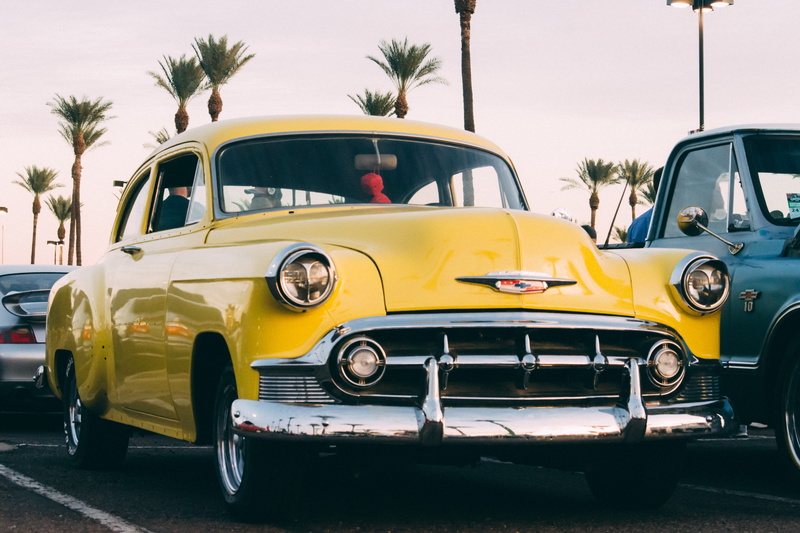 stationary, no people, travel, car show, transportation, vintage car, road, parked, motor vehicle, arecaceae, car wheel, sky, yellow, taxi, palm tree, machine