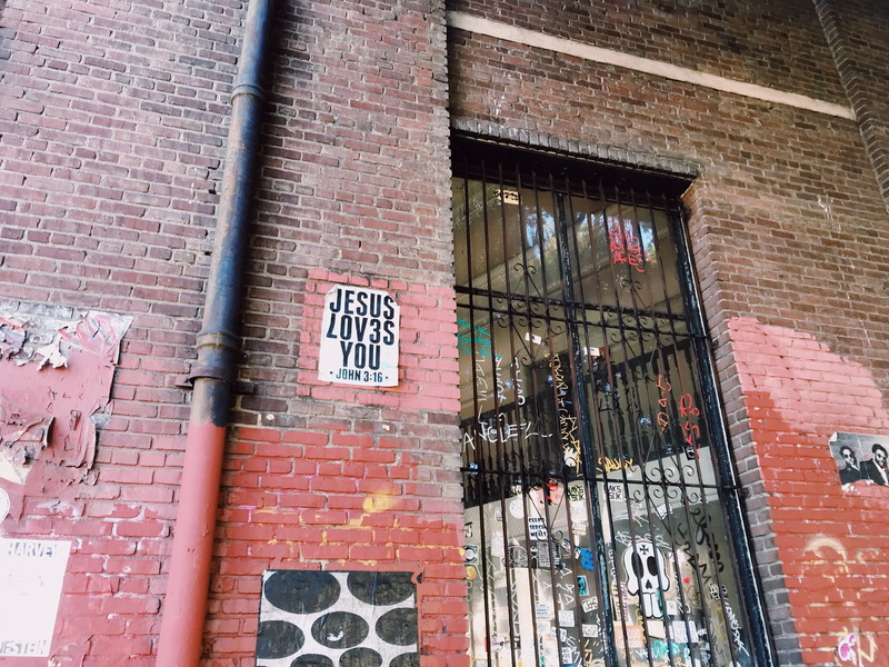 low angle view, downtown, graffiti, wall - building feature, los angeles, city, western script, urban, sign, street art, white, building exterior, jesus