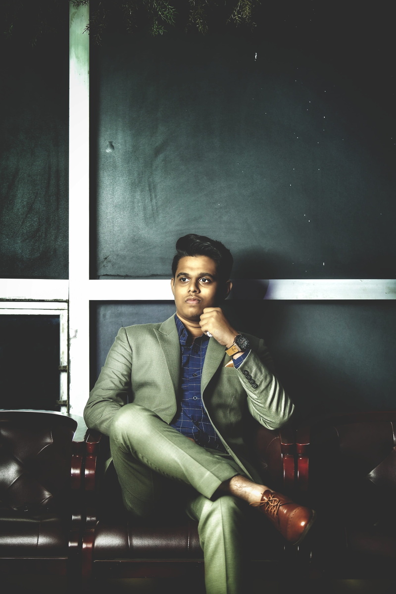 lounge chairs, hairstyle, leather shoes, 2K, indoors, front view, clothing, confidence, pants, person, looking at camera, casual clothing, suit, lapel