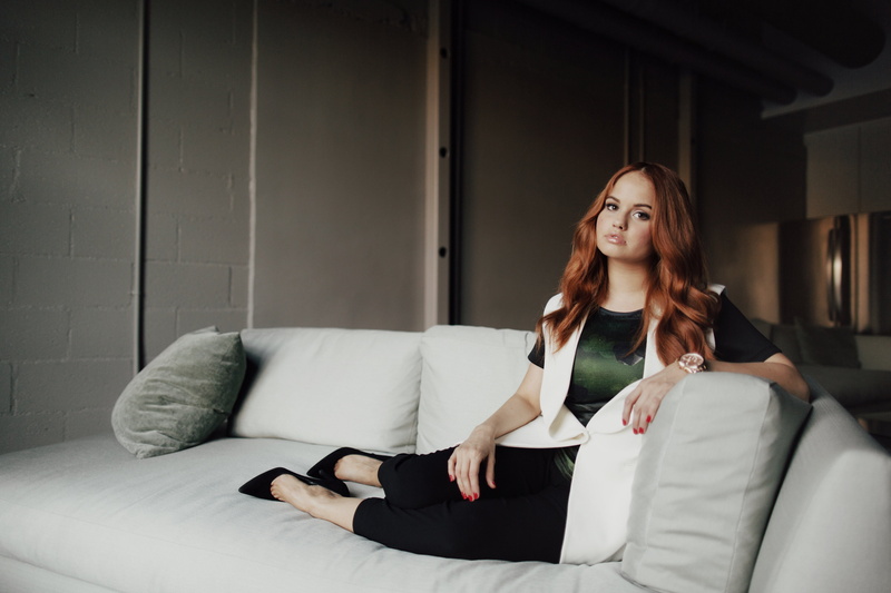 pillow, singer, long hair, couch, juicy lips, looking at viewer, women, 2K, Debby Ryan, high heels, redhead, pants, watch, sitting, red nails, actress
