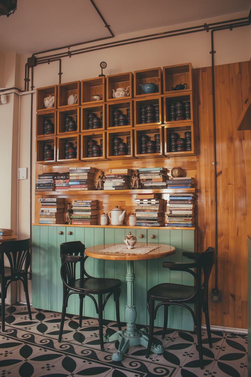 decor, no people, inside, coffee table, flooring, two, interior design, chairs, cafe, architecture, books, seat, black, glass - material, shelves, restaurant