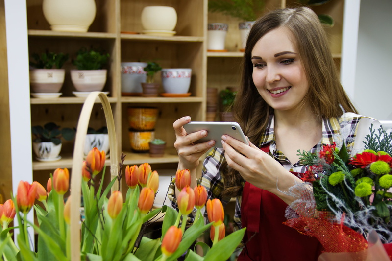 holding, job, shop, woman, emotion, work, young adult, flowers, adult, wireless technology, taking, lifestyles, hairstyle, merchandise, one person, smartphone
