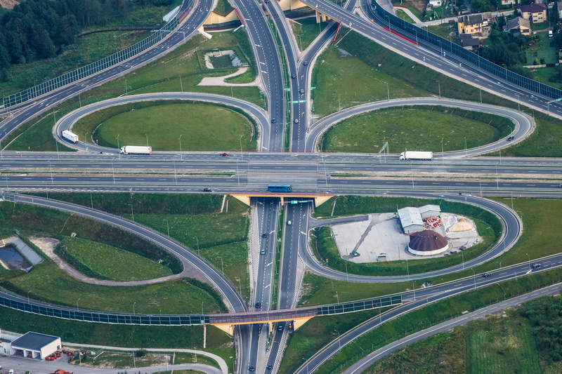 land vehicle, aerial photo, transport hub, overpass, way, building exterior, aerial view, pattern, multiple lane highway, city, green color, communication