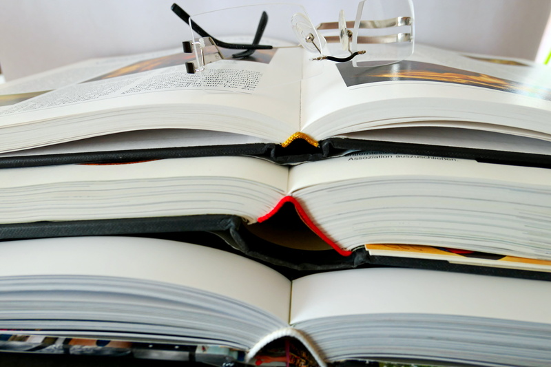 opened, book pages, large group of objects, indoors, books, page, learn, reading, group of objects, read, text, bound, still life, stacked, education, no people