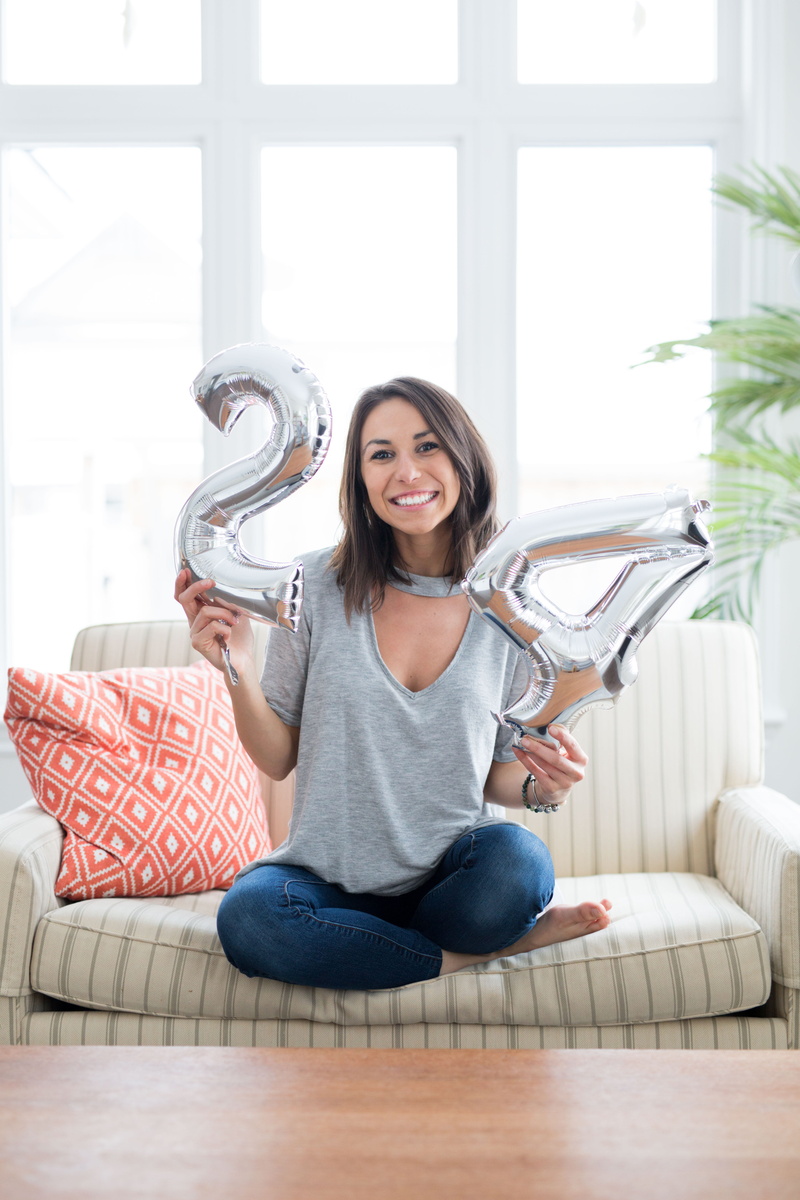 front view, portrait, number, sitting, women, silver, airy, leisure activity, 24, flooring, balloons, hairstyle, brunette, emotion, pillow, cushion, young adult
