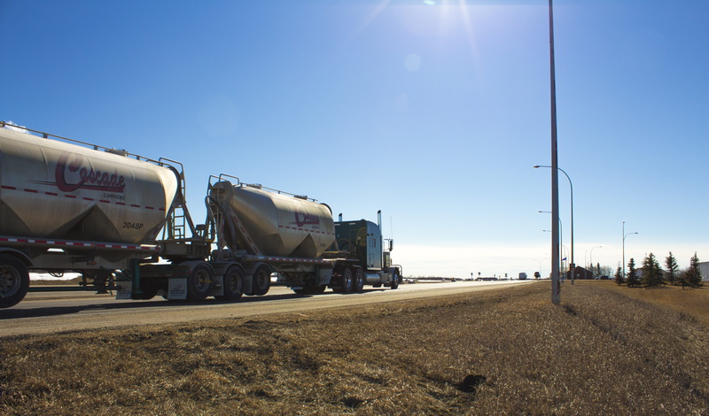 mode of transportation, outdoors, highway, oil industry, Truck, lens flare, clear sky, land vehicle, road, sky, fuel tanker, trucking, sunlight, multiple lane highway