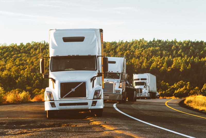large, truck, no people, semi-truck, commercial land vehicle, trucks, blur, day, sky, outdoors, tree, trees, landscape, trip (journey), freight transportation