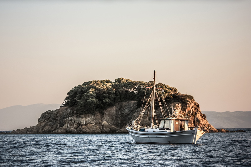 boat, white, rock - object, mode of transportation, land, idyllic, island, beauty in nature, sailing, craggy, copy space, view, vacation, sky, outdoors