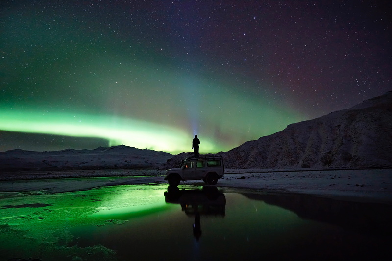sky, space and astronomy, one person, suv, people, astronomy, outdoors, green color, front, water, standing, galaxy, nature, top, stars, man, mountain