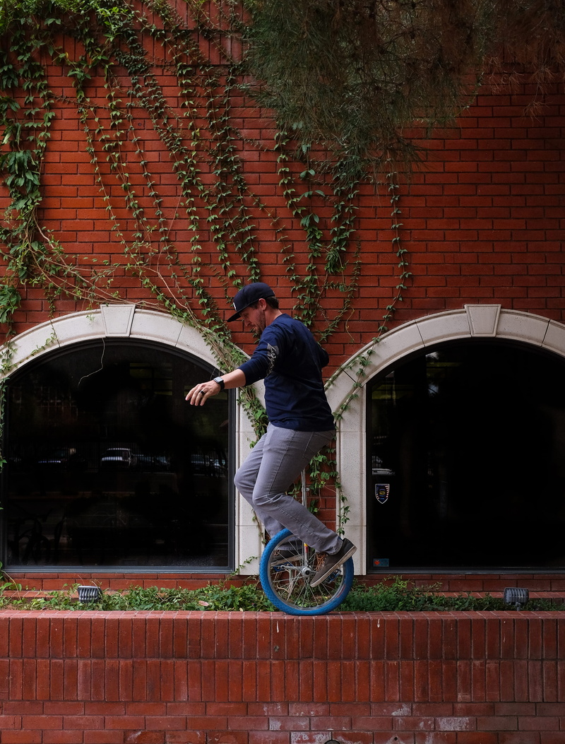 brick, red, 4K, plant, green, unicycle, dangerous, united states, mode of transportation, wall, casual clothing, lifestyles, real people, full length