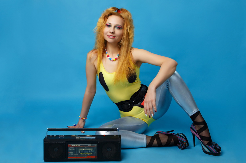 hairstyle, retro styled, the style of the 80-ies, bouffant, adult, portrait, blue background, bodysuit, 5K, blue, posture, blond hair, tape recorder, corrugation hair